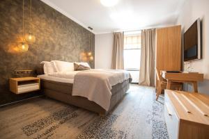 ein Schlafzimmer mit Bett, Schreibtisch und Fernseher in der Unterkunft Ratshotel in Haltern + 48 Fotos