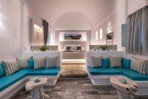 a living room with blue and white furniture at Anastasia Princess Luxury Residence - Adults Only in Perissa