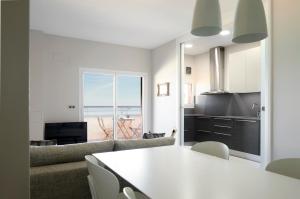 cocina y sala de estar con mesa blanca en Sunset by FeelFree Rentals, en San Sebastián