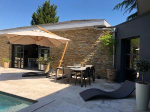 une terrasse avec une table et un parasol dans l'établissement Chambre d'hôte Bordeaux, à Bordeaux