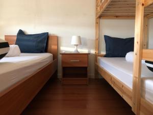 ヴィアナ・ド・カステロにあるCasa das Coresのベッドルーム1室(二段ベッド2台、ナイトスタンドのランプ付)