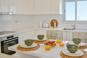 eine Küche mit vier Schüsseln Essen auf dem Tisch in der Unterkunft Phaedrus Living: Seaside Luxury Flat Lighthouse 67 in Paphos City