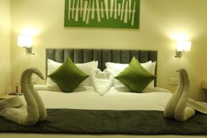 A bed or beds in a room at Regenta Central Harsha Vapi