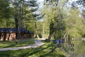 a cabin next to a river with trees and a path at Cabanes d'Aiguebelette in Saint-Alban-de-Montbel