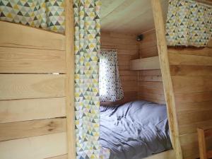 a bedroom with a bunk bed in a log cabin at Air de Camping - Chemin de Traverse in Auberive