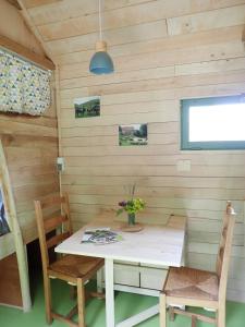 a table and chairs in a room with wooden walls at Air de Camping - Chemin de Traverse in Auberive