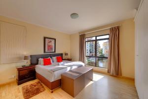 a bedroom with a large bed and a window at Majorca Self-Catering Apartments in Cape Town