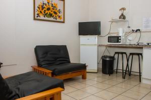 a living room with a chair and a microwave at Helderzicht Self-Catering in Brackenfell