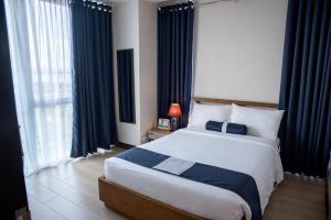 a bedroom with a large bed and a large window at C Suites at Mactan Newtown in Mactan