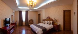 a hotel room with a bed and a chandelier at Dormitory Hualing Tbilisi in Tbilisi City