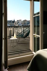 a room with a view of a balcony with a chair at Royal Madeleine Hotel & Spa in Paris