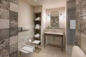 a bathroom with a sink and a toilet and a mirror at Royal Madeleine Hotel & Spa in Paris