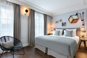 a bedroom with a large bed and a chair at Royal Madeleine Hotel & Spa in Paris