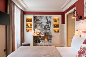 a bedroom with a bed and a desk in a room at Royal Madeleine Hotel & Spa in Paris