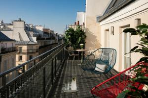 a balcony with a chair and a table and a cat at Royal Madeleine Hotel & Spa in Paris