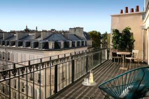 a balcony with a table and chairs and buildings at Royal Madeleine Hotel & Spa in Paris