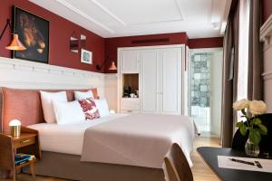 a bedroom with a white bed and red walls at Royal Madeleine Hotel & Spa in Paris
