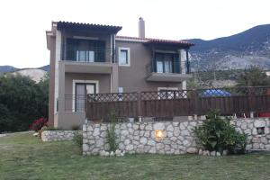 a house with a stone wall and a fence at Villa Nefeli in Trapezaki