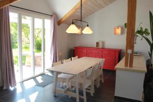 eine Küche mit einem Holztisch und einem roten Schrank in der Unterkunft Gîte le Cerf Volant in Raon-sur-Plaine