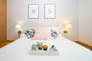 a white bed with a tray of food on it at Apartamentos Plaza de España in Madrid