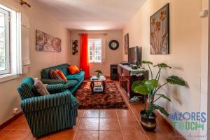 a living room with two couches and a tv at House Rebelo in Terra Chã
