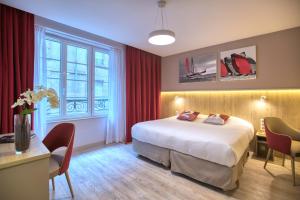 圣马洛Hôtel des Marins, Saint-Malo的一间带床、桌椅的酒店房间