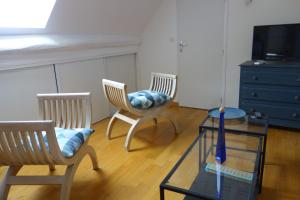 a living room with two chairs and a glass table at LA MAISON DE ROSE in Limeray