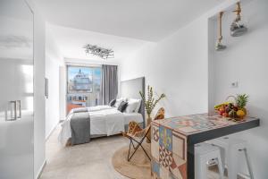 a white bedroom with a bed and a desk at Mythos Luxury Suites in Athens