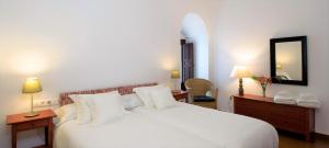 a bedroom with a large white bed and a mirror at Entre 2 Mezquitas in Córdoba