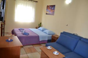a bedroom with a bed and a blue couch at Apartments Milosevic in Bar