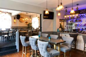 a restaurant with tables and chairs and a bar at The Derby Hotel in Barrow in Furness