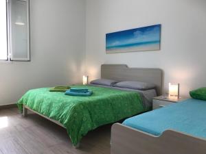 トッレ・ラピッロにあるVilletta Cristinaのベッドルーム1室(緑色のベッドカバー付)