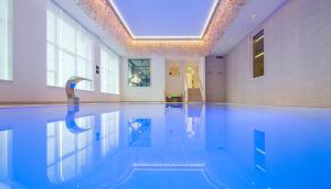 a swimming pool in a building with a ceiling at Van der Valk Hotel Vianen - Utrecht in Vianen