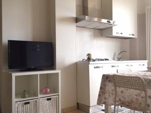 a kitchen with a tv on a stand with a table at Appartamento Mare Nardo in Porto SantʼElpidio