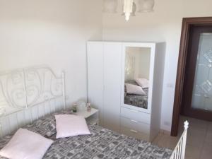 a white bedroom with a bed and a mirror at Appartamento Mare Nardo in Porto SantʼElpidio