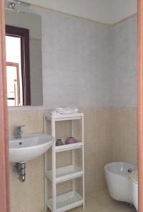 a bathroom with a sink and a toilet and a tub at Appartamento Mare Nardo in Porto SantʼElpidio