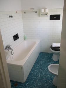 bagno bianco con vasca e servizi igienici di Hotel Italia a Senigallia