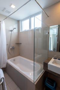 a bathroom with a tub and a sink at C Suites at Mactan Newtown in Mactan