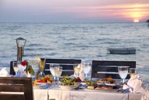 a table with plates of food and drinks on the ocean at Ephesia Holiday Beach Club in Kuşadası