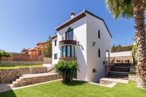 una casa blanca con escaleras y una palmera en Villa La Piedad, en Otura
