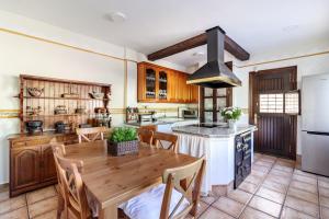 a kitchen with a wooden table with chairs and a stove at Villa La Piedad in Otura