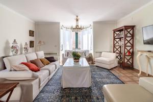 ein Wohnzimmer mit weißen Möbeln und einem Kronleuchter in der Unterkunft Villa La Piedad in Otura