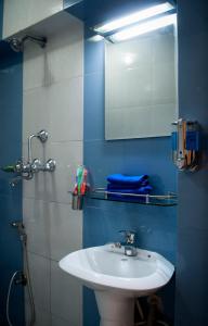 y baño con lavabo y espejo. en Cosy Hotel, en Bhaktapur
