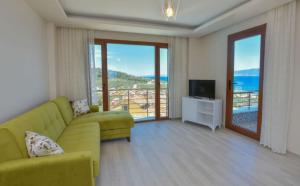 a living room with a green couch and a television at Erpey Ferah Apart Otel in Balıkesir