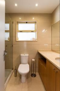 a bathroom with a toilet and a sink and a window at Porto Gaia City House by MP in Vila Nova de Gaia