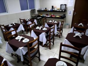 un comedor con mesas y sillas con servilletas. en Hotel Garden Itaim, en São Paulo