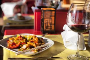 a plate of food next to a glass of wine at Ephesia Holiday Beach Club in Kuşadası