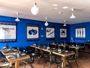 a dining room with wooden tables and blue walls at Vale d'El Rei Hotel & Villas in Carvoeiro
