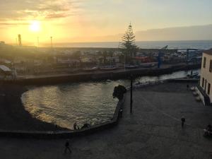 a person walking on the beach with the sunset in the background at SUN-SEA in Puerto de la Cruz