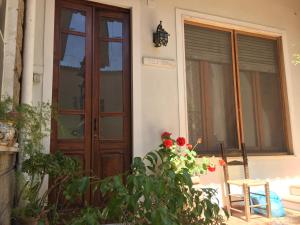 a door of a house with red flowers in front of it at Villa Serra B&B iun E6769 in Oristano